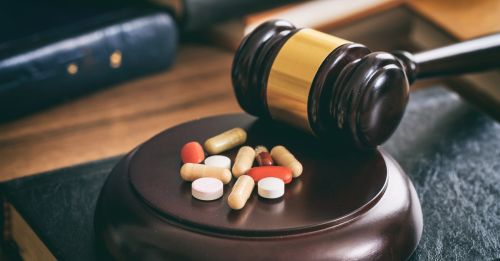 Law gavel and colorful pills. Drug possession defense attorney concept.