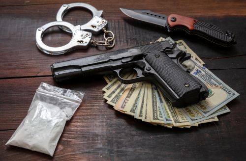 Drugs narcotics possession and use, arrest and punishment for illegal business concept. Cocaine plastic packets, pistol US dollars and handcuffs.