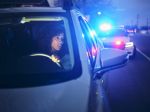 A young woman, being stopped by police at night for a traffic violation concept