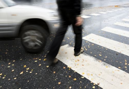 Man on pedestrian crossing in autumn, in danger of being hit by carMan on pedestrian crossing in autumn, in danger of being hit by car concept