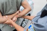 Unrecognizable police officer arrests individual for traffic violation concept
