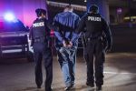 Handcuffed suspect being arrested by police at night