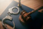 Handcuffs and wooden gavel. Crime concept.